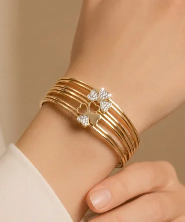 Gold multi-layer bangle with diamond heart design on hand