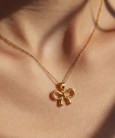 Gold plated bow pendant necklace with anti-tarnish cable chain on white background