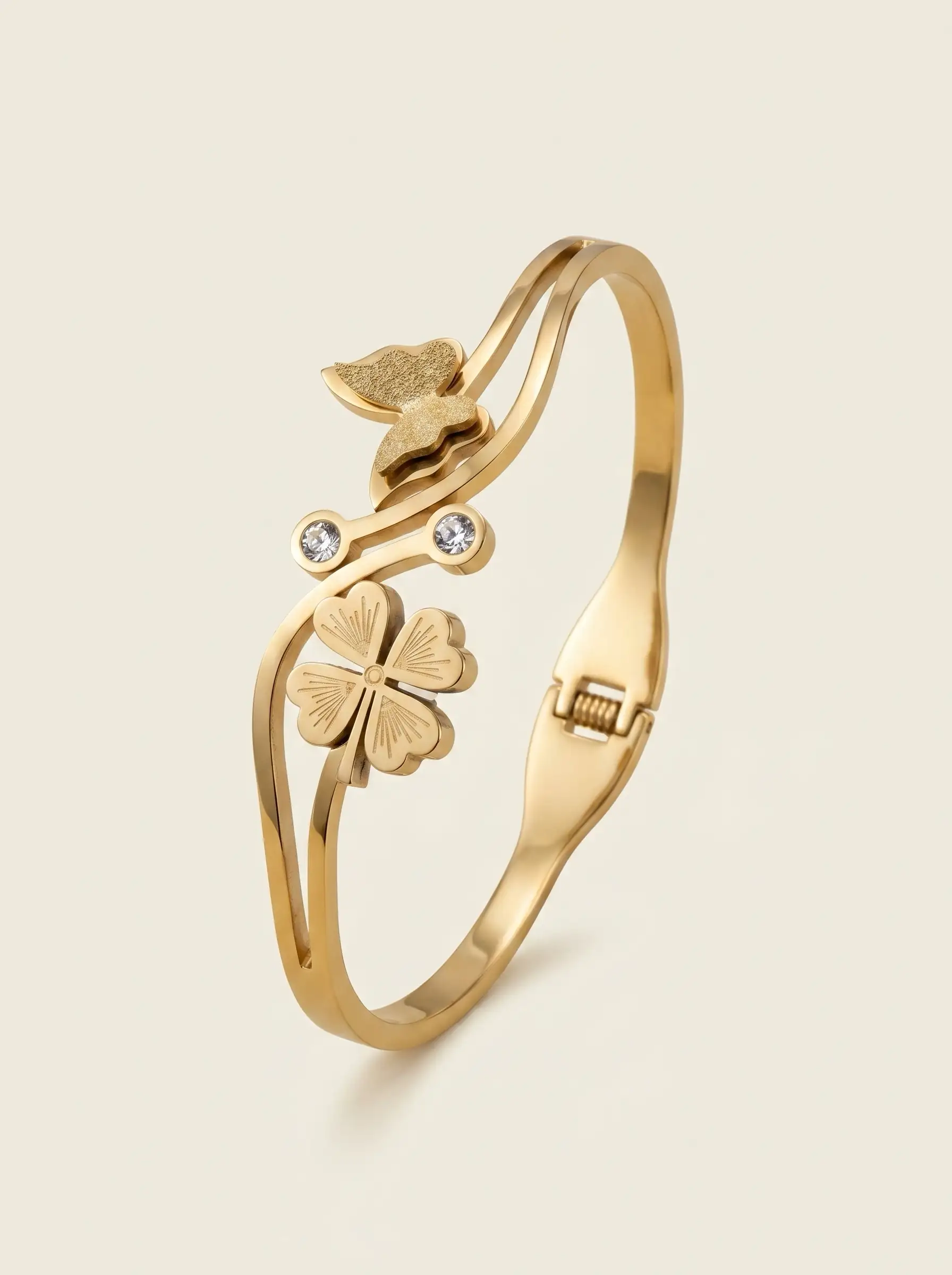 Gold plated bracelet with floral charm and butterfly detail on structured band for women