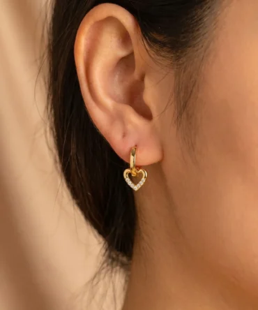 Close-up of gold plated heart drop hoop earrings with crystal detailing for women