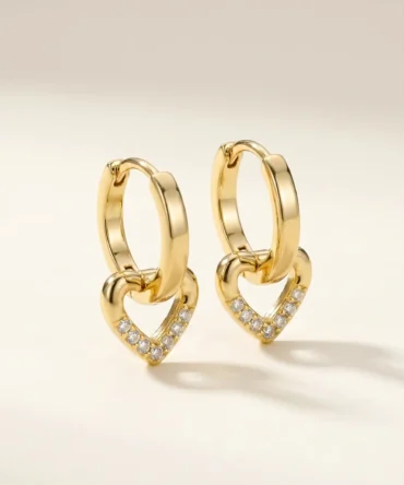 Close-up of gold plated heart drop hoop earrings with crystal detailing for women