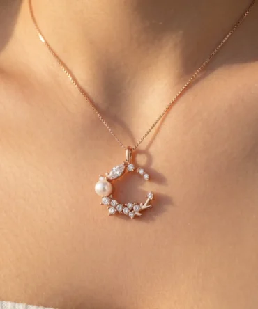 Rose gold tone moon shaped pendant with crystal cluster and pearl detail for women