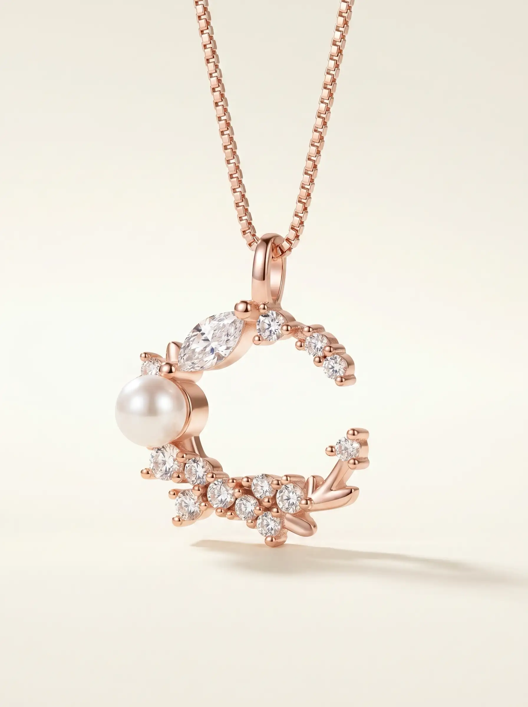 Rose gold tone moon shaped pendant with crystal cluster and pearl detail for women