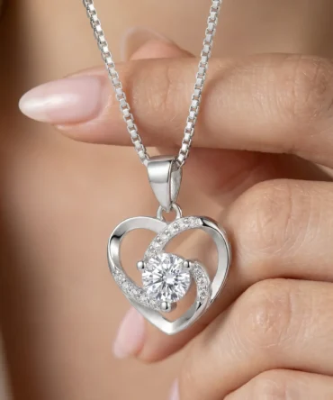 Silver tone heart shaped pendant with central crystal and curved studded detailing for women