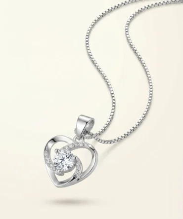 Silver tone heart shaped pendant with central crystal and curved studded detailing for women