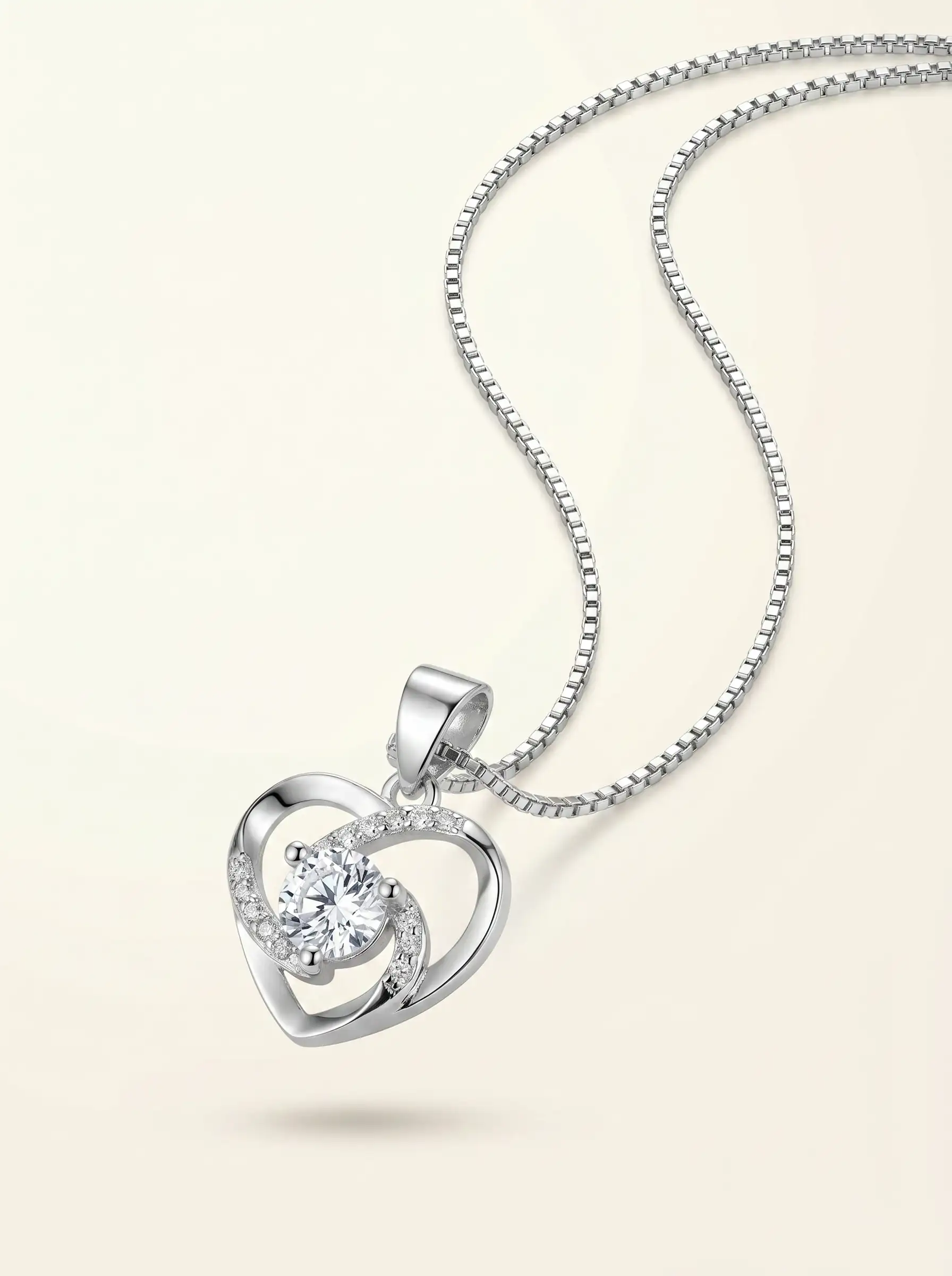 Silver tone heart shaped pendant with central crystal and curved studded detailing for women